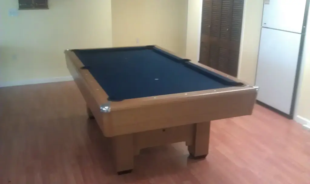 A black felt table on a blond oak base in a bright room